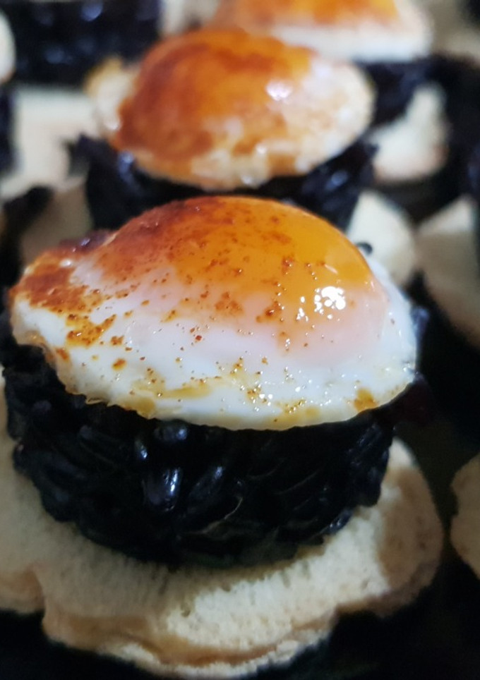 Una foto de Arroz negro Venere con huevo de codorniz