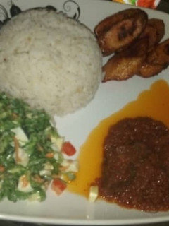 A picture of Rice stew with salad & plantain.