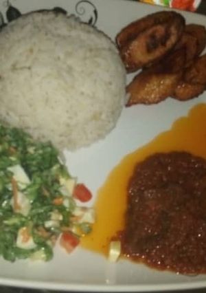 A picture of Rice stew with salad & plantain.