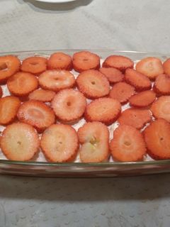 Una foto de Postre de bizcochos, fresas y nata