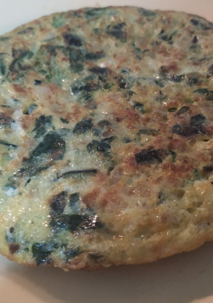 Una foto de Tortilla de calabacín, espinacas, cebolla y especias