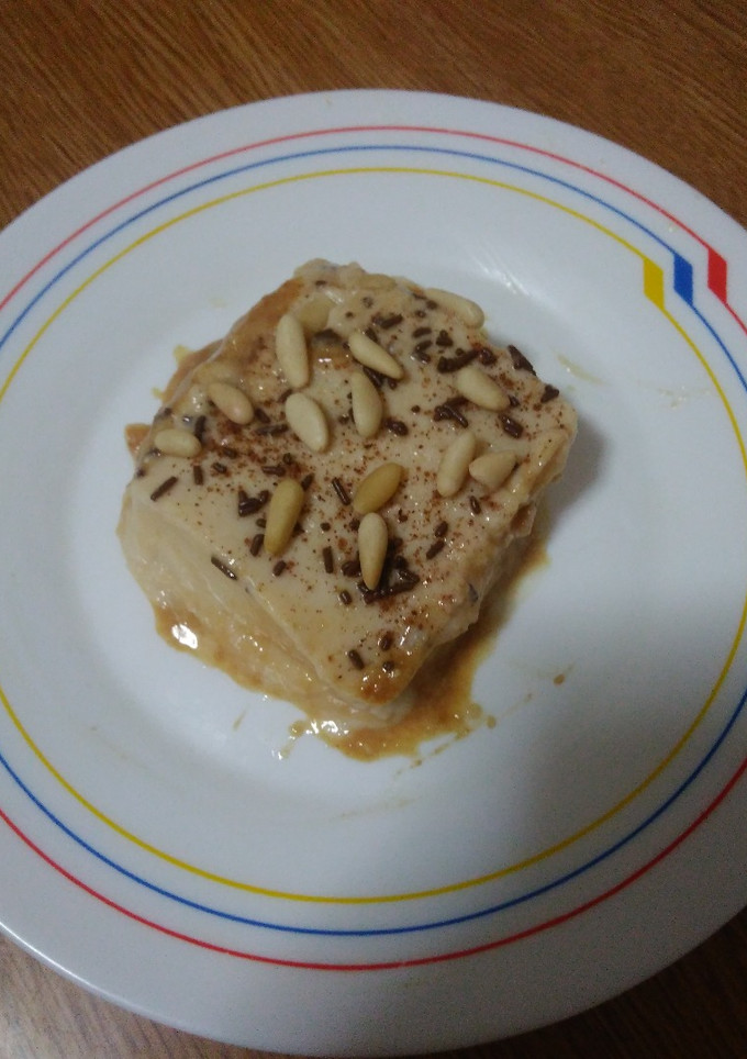 Una foto de Pastel cuajada de bizcochos, manzanas y piñones