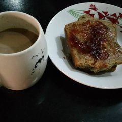 A picture of Sliced bread with jam and coffee.