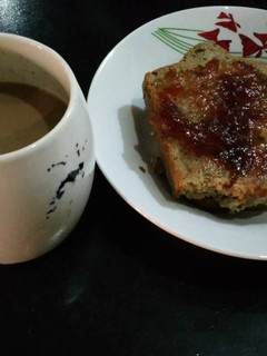 A picture of Sliced bread with jam and coffee.