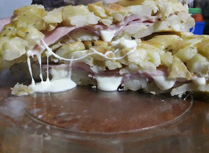 Una foto de Tortilla de papas rellena de jamón y queso fresco