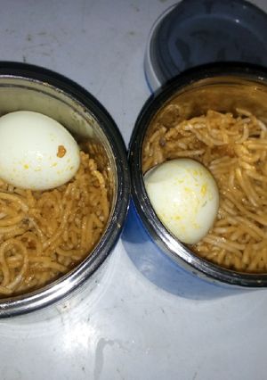 A picture of Jollof spaghetti and boiled egg.