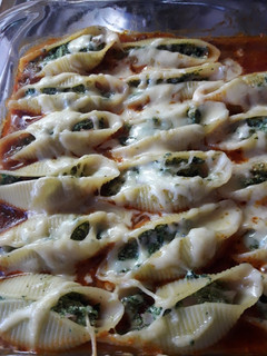 Una foto de Conchiglioni relleno de espinaca y ricota sobre salsa boloñesa
