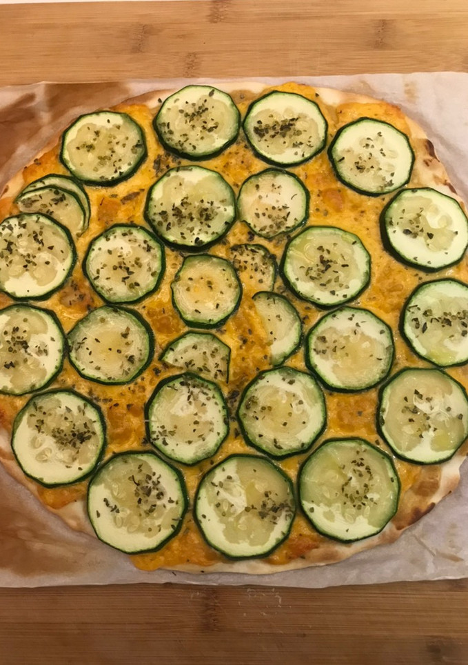 Una foto de Pizza de mostaza, queso cheddar y calabacín