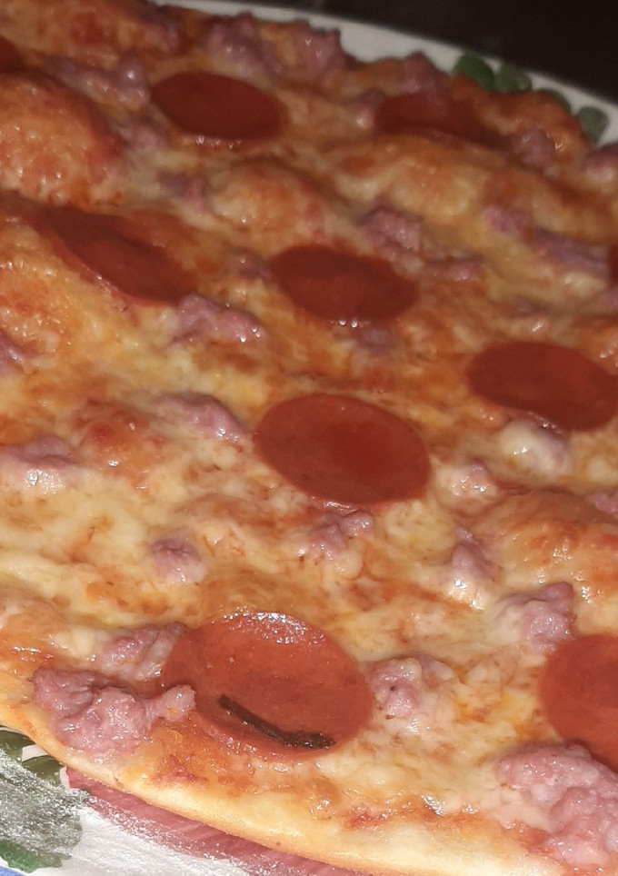 Una foto de Pizza casera de pepperoni y carne picada