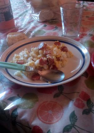 Una foto de Salchicha revuelta con huevo y acompañado de un puñado de arroz