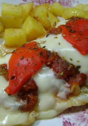 Una foto de Merluza a la pizza con papas crocantes