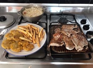 Una foto de Lomo de cerdo asado con arroz blanco patacones y tiras de yuca