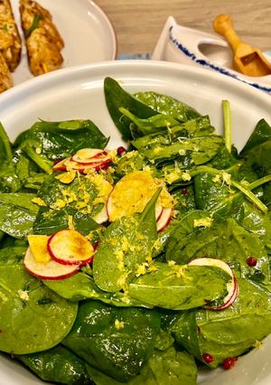 Une photo de Salade de jeunes pousses d’épinards au curry et à l’ail accompagnée de mini brochettes de dinde