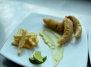 Una foto de Bastones de pescado redondo y papas fritas, estilo Fish And chips con salsa tártara. 🐟🤪