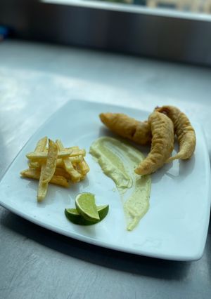 Una foto de Bastones de pescado redondo y papas fritas, estilo Fish And chips con salsa tártara. 🐟🤪