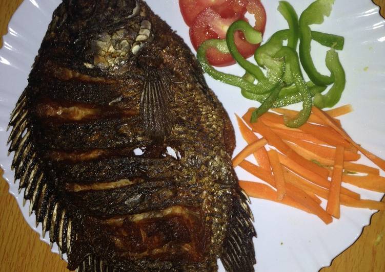 How to Prepare Homemade Deep fried fish garnished with green pepper, carrots and tomatoes