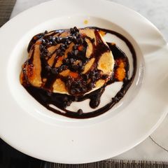 A picture of Banana pancakes with chocolate sauce.