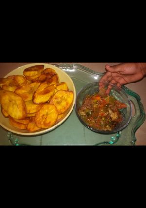 A picture of Fried plantain served with titus fish and vegetable sauce.
