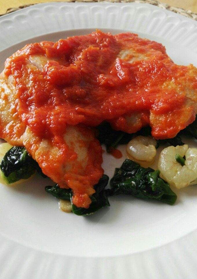 Una foto de Merluza en salsa de pimientos con gambas y espinacas