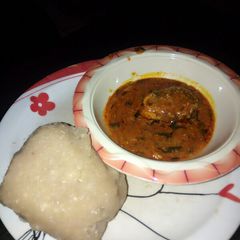 A picture of Eba and my local beans soup slightly garnished with scent leaves.