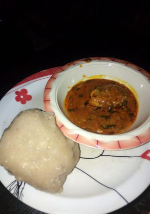 A picture of Eba and my local beans soup slightly garnished with scent leaves.