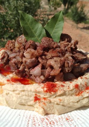A picture of Braised Lamb Shanks with Hummus Moutabal.