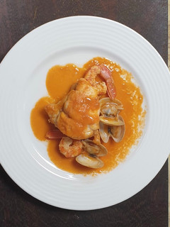 Una foto de Rape al whisky con crema de bogavante gambones y almejas