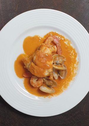 Una foto de Rape al whisky con crema de bogavante gambones y almejas