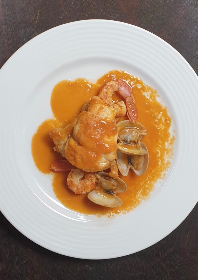 Una foto de Rape al whisky con crema de bogavante gambones y almejas