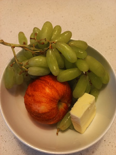 A picture of Apple, grape, cheese snack.
