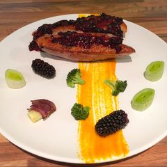 A picture of Sous vide duck breast, blackberry sauce, roasted vegetables.