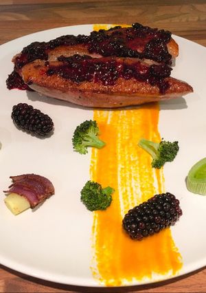 A picture of Sous vide duck breast, blackberry sauce, roasted vegetables.