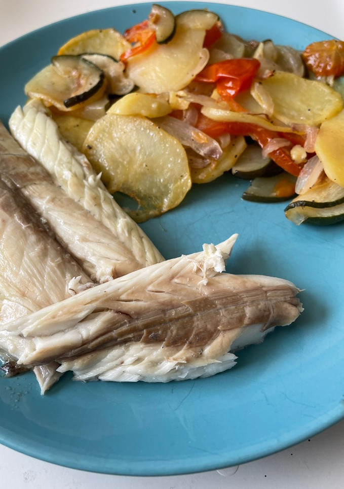 Una foto de Lubina al horno con patatas y verduras