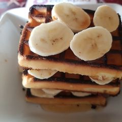 A picture of Toasted Waffles layered with Banana and Runny Honey.