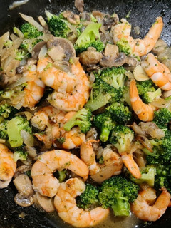 Una foto de Wok de langostinos salteados con brócoli y champiñones