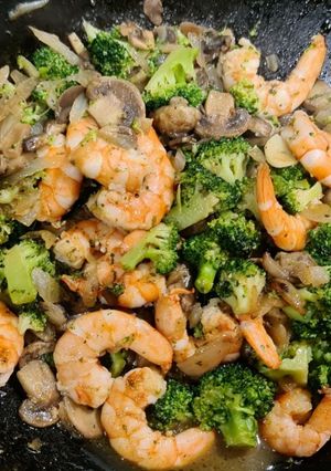 Una foto de Wok de langostinos salteados con brócoli y champiñones