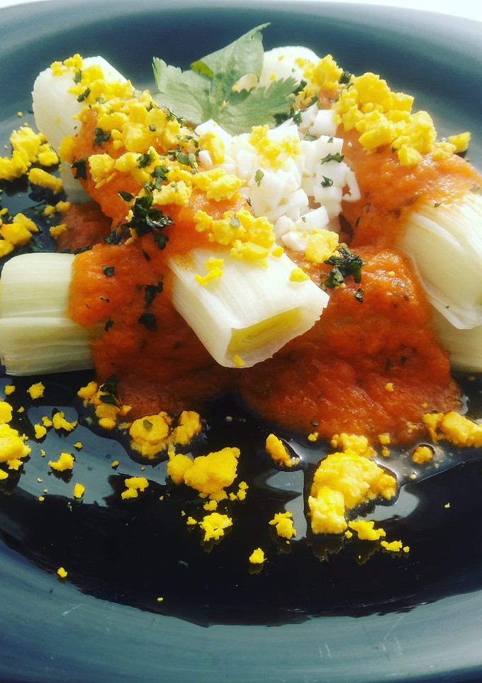Una foto de Puerros cocidos con salsa de tomate y huevo cocido