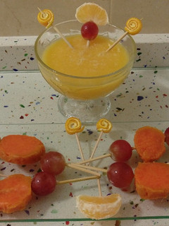 Una foto de Smoothie de mandarinas con piruletas de boniato y uvas