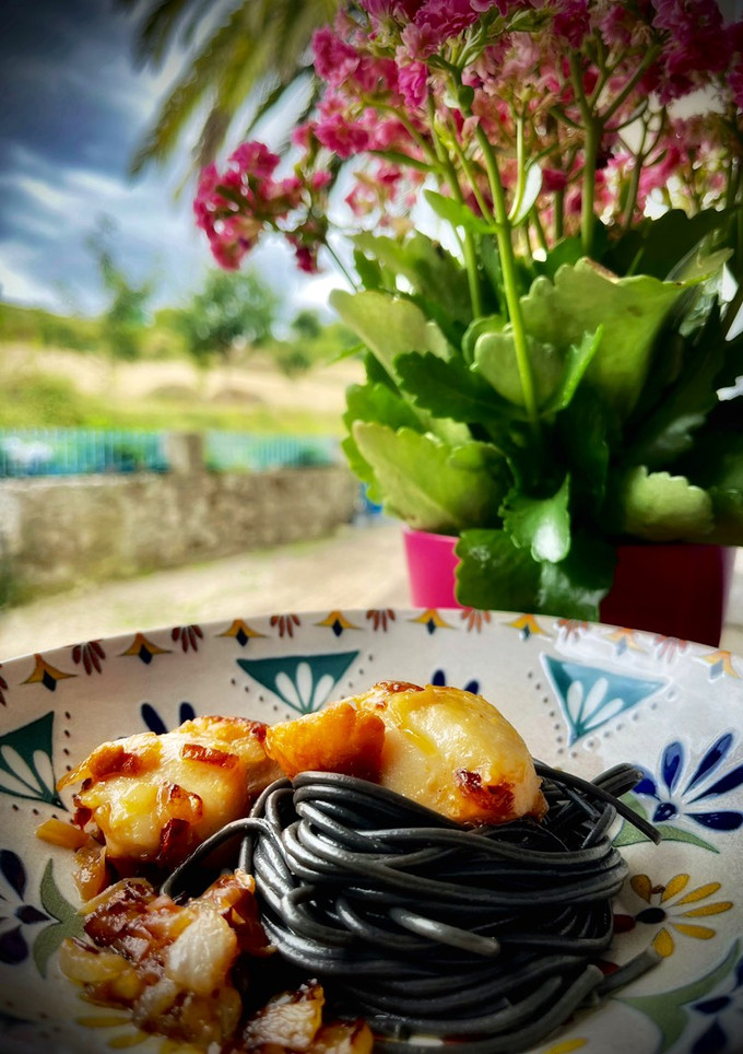 Una foto de Spaghetti al negro di sepia con vieiras