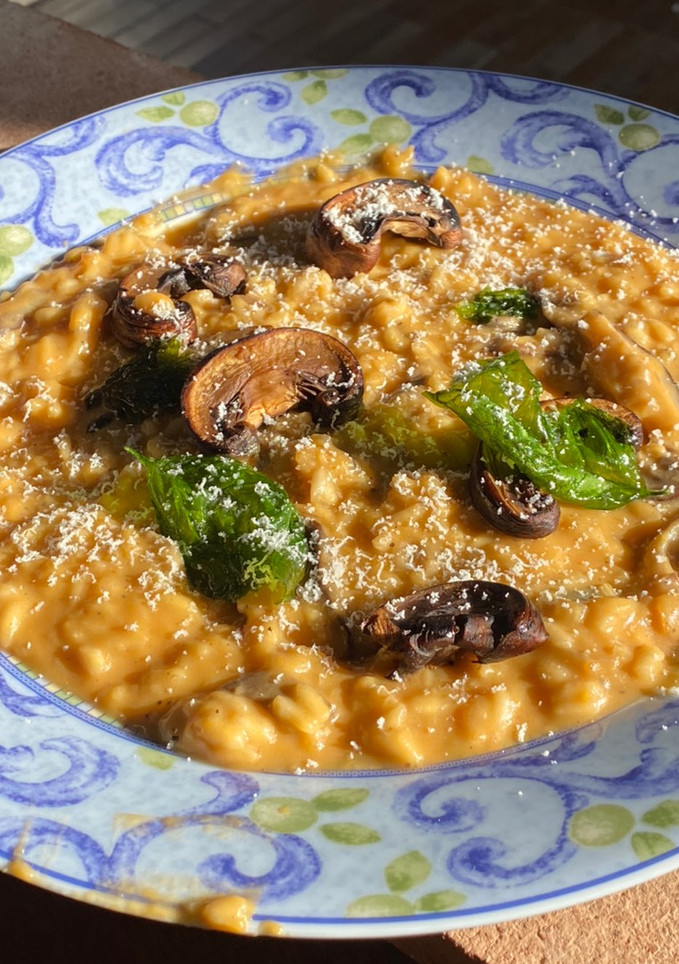 Una foto de Risotto de crema de boniato y setas con crujiente de albahaca