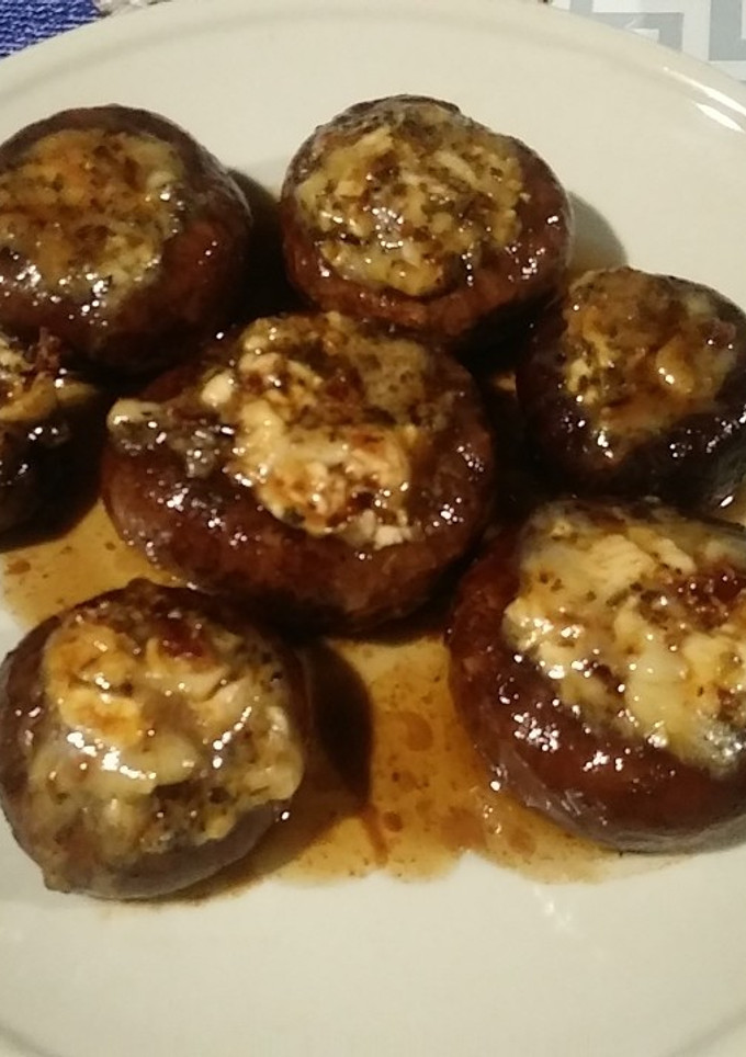 Una foto de Champiñones a la pancha con tomate seco y queso