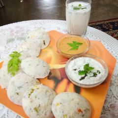 A picture of Veggie Idlis with coconut and red chutney.