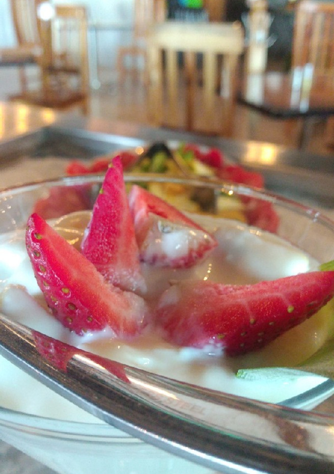 Una foto de Yogurth con granola y miel a las fresas