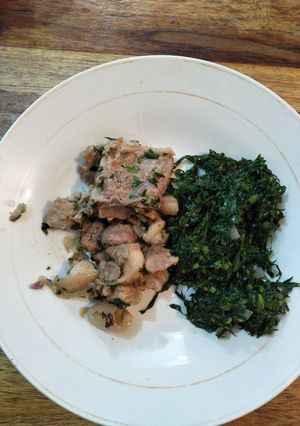 A picture of Fried pork with greens.
