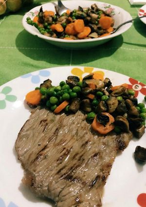 Foto di Fettina di manzo arrostita con contorno di piselli, carote e funghi