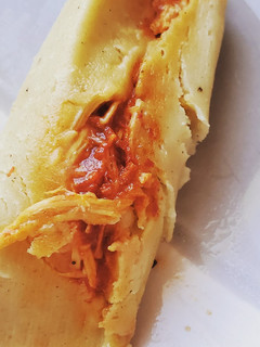 Una foto de Tamales rojos en hoja de maíz