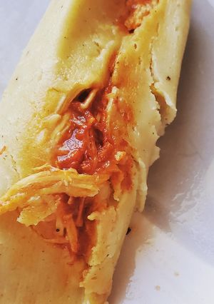 Una foto de Tamales rojos en hoja de maíz