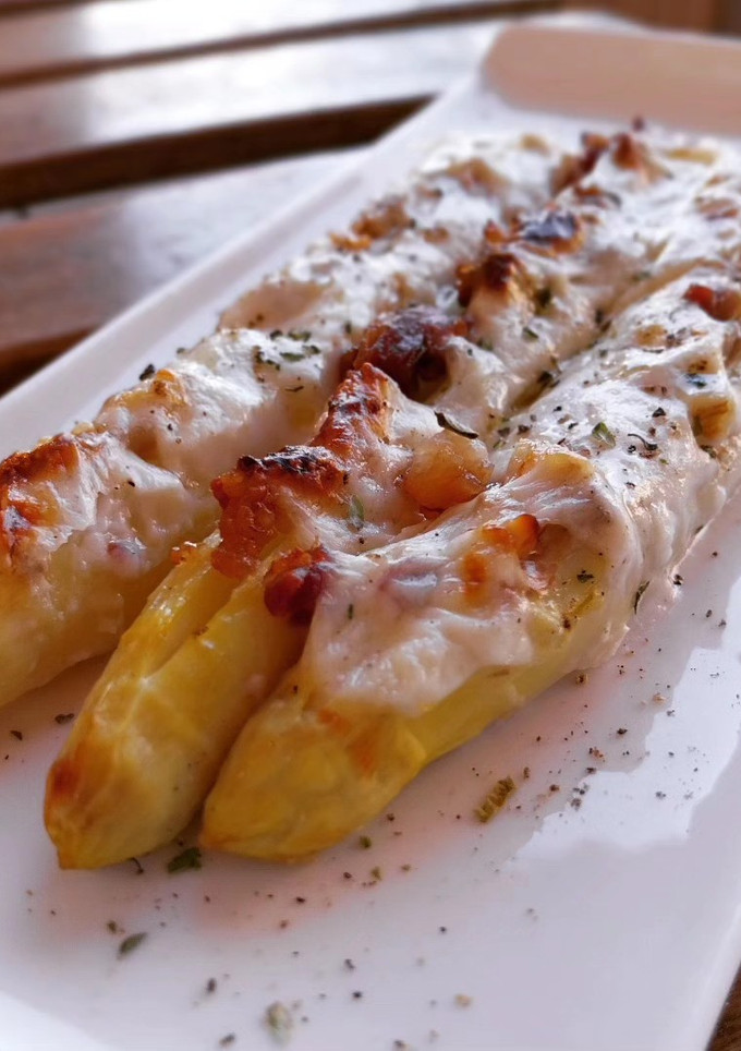 Una foto de Espárragos blancos gratinados rellenos de panceta ibérica y nueces