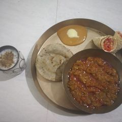 A picture of Mashed Aubergine Curry with Pearl Millet bread.
