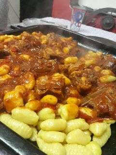 Una foto de Ñoquis de papa con salsa